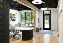 Inside a Custom Home Design and Build Firm’s Office Remodel Custom-designed metal shelves blend color, depth, and functionality.