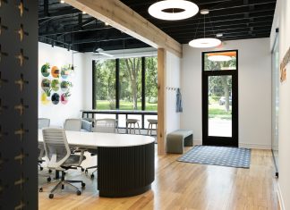 Inside a Custom Home Design and Build Firm’s Office Remodel Custom-designed metal shelves blend color, depth, and functionality.