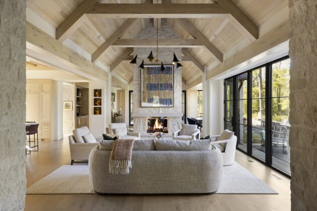 Light-toned wood accents echo the home&rsquo;s exterior stonework, and the wood ceiling in the entertaining room adds warmth to the vaulted space. A piece from the homeowners&rsquo; art collection takes center stage on the wall above the fireplace.