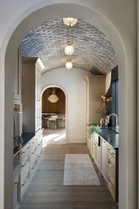 An archway leads to a refined butler's pantry that houses smart storage and elevated amenities