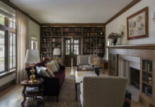 Home library with doors at the back that lead into an office space