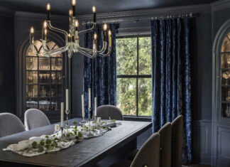 Drenched in navy grasscloth with a variety of rich accents, this dining room delivers drama and elegance.
