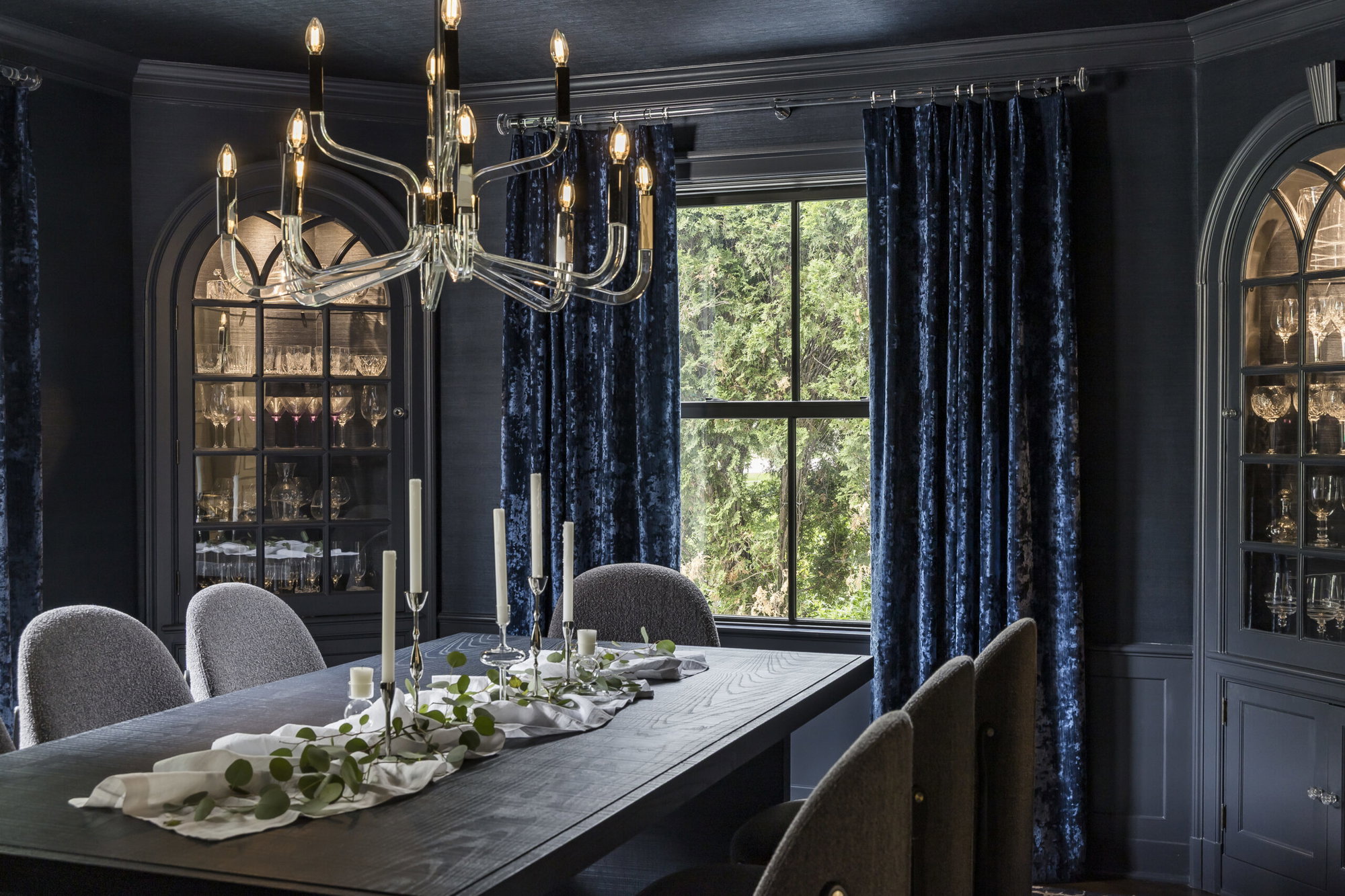 Drenched in navy grasscloth with a variety of rich accents, this dining room delivers drama and elegance.